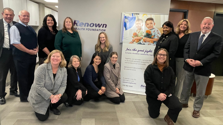 The team at Renown Health Foundation pose for a group photo in front of a Renown Health Foundation sign.
