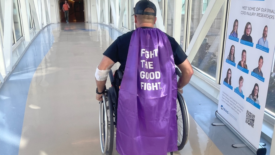 Jason Simpson in a Fight the Good Fight cape while in a wheelchair.