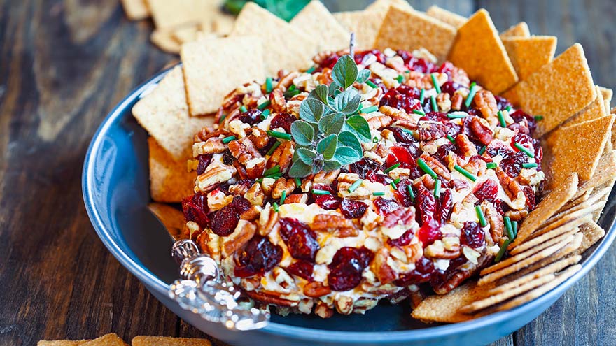 Cranberry cream cheese dip in blue dish with cracker