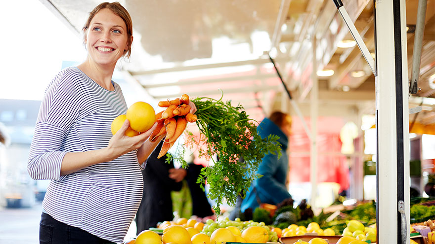 Pregnant woman shopping for vegetables