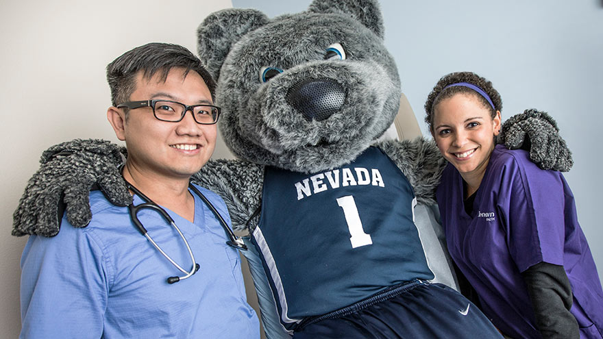 Renown provider and nurse posing with UNR mascot, Wolfie.