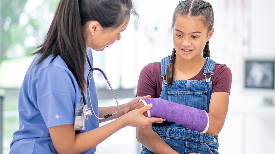 Provider examining child with arm cast